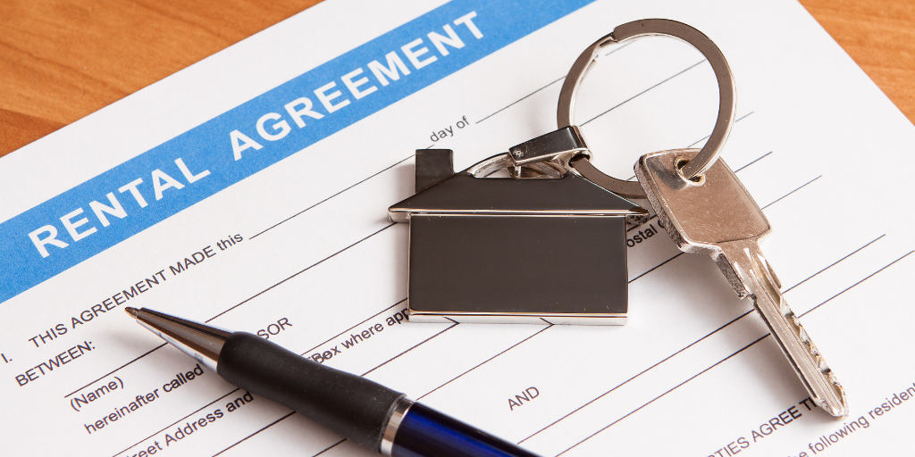 an image of a rental lease, pen and house-shaped key chain